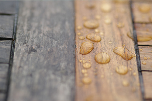 Wasser perlt von behandeltem Holz ab