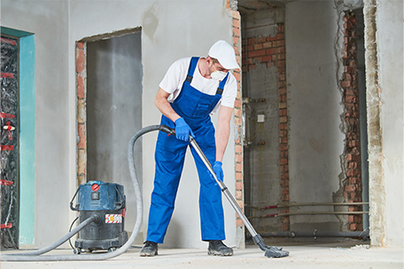 Mitarbeiter saugt auf einer Baustelle